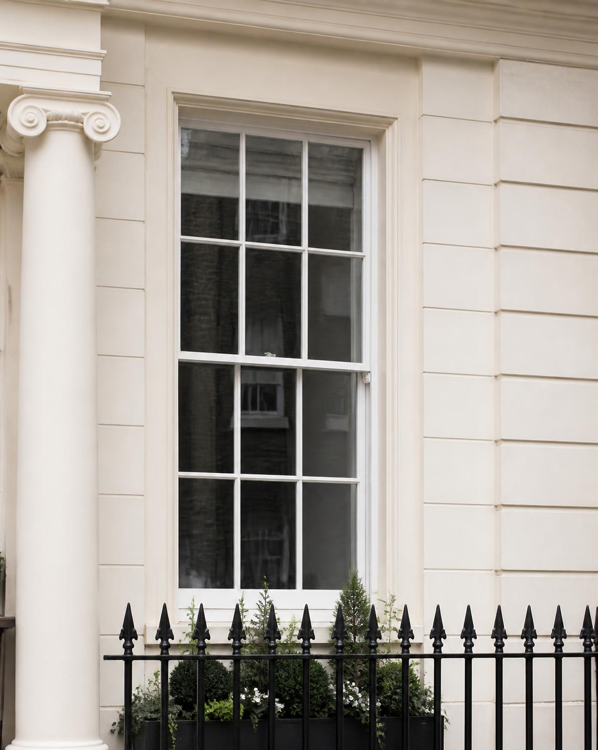 Detail of a Georgian stucco facade and sash window in Prime Central London